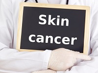 coral springs dermatologist holding skin cancer sign